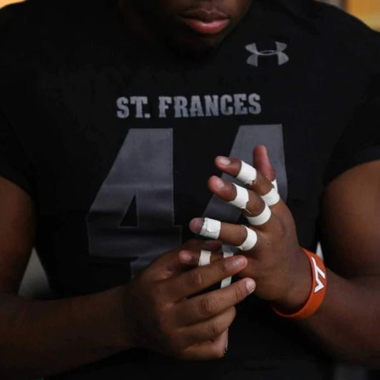 St. Frances football player massaging hand inury
